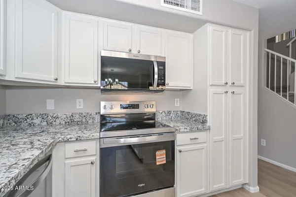 a kitchen with stainless steel appliances granite countertop a stove top oven a sink and a refrigerator