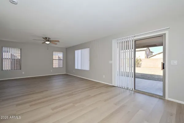 a view of an empty room with wooden floor and stairs