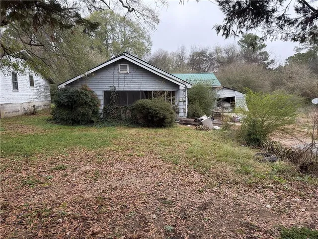 a view of a house with a yard and large trees