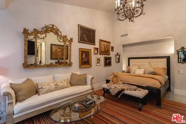 a bedroom with a bed a flat screen tv and balcony view