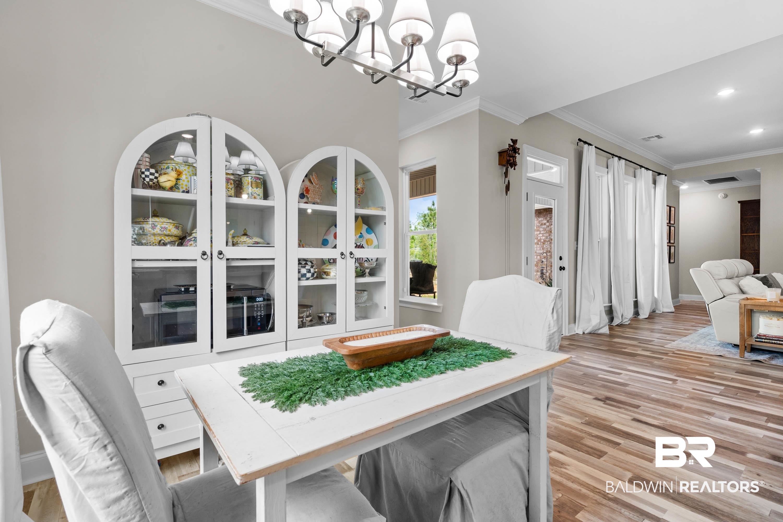 7150 Powell Road, Unit LOT 6A Eight Mile, AL 36613 - Photo 9 of 35 Dining area featuring ornamental molding, light wood finished floors, a chandelier, and arched walkways