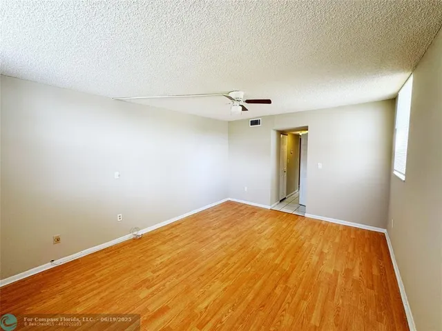 a view of empty room with wooden floor