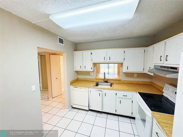 a kitchen with a sink window and cabinets