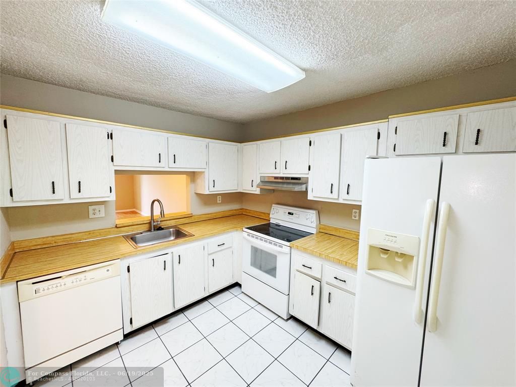 1820 Southwest 81st Avenue, Unit 3201 North Lauderdale, FL 33068 - Photo 3 of 20 a kitchen with white cabinets and white appliances