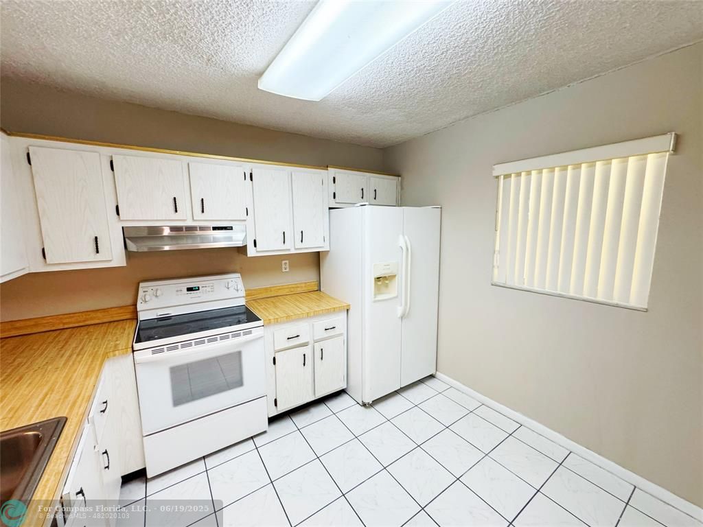 1820 Southwest 81st Avenue, Unit 3201 North Lauderdale, FL 33068 - Photo 4 of 20 a kitchen with white cabinets and white appliances