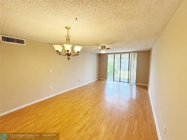a view of a room with wooden floor fan and window