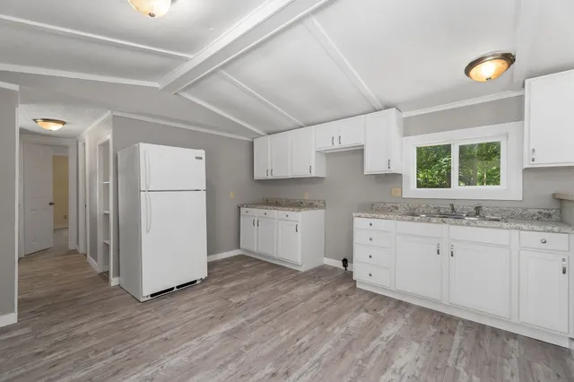 a kitchen with granite countertop white cabinets and white appliances