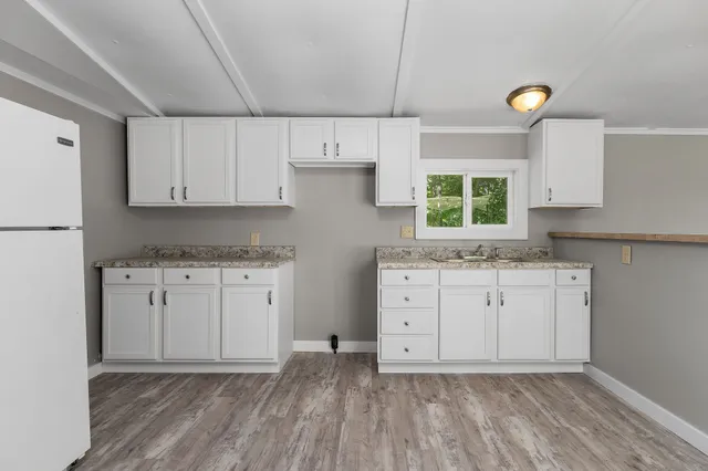 a room with a stove a sink and a window