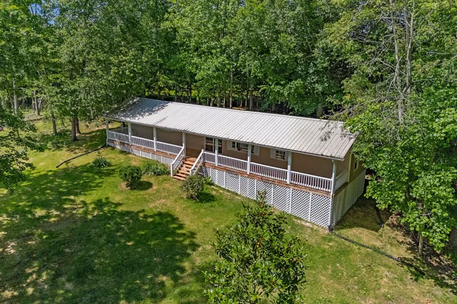 a aerial view of a house with a yard and large trees