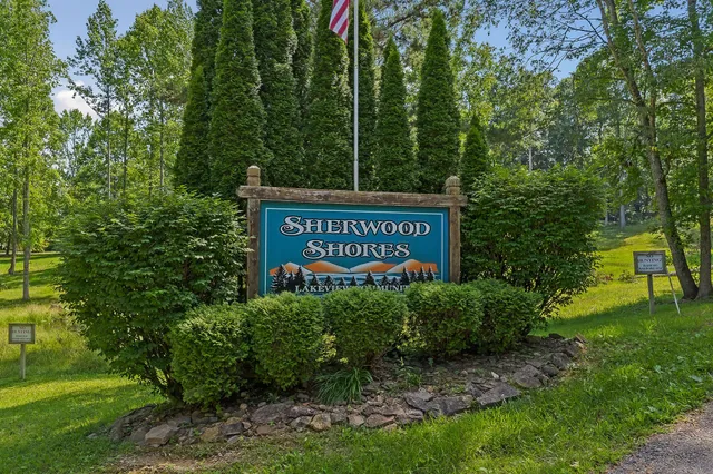 a sign that is sitting in front of a tree