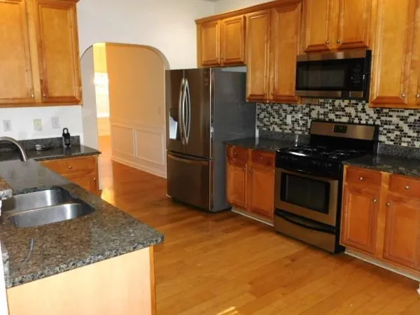 a kitchen with stainless steel appliances granite countertop a refrigerator stove and microwave