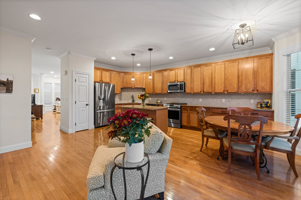 13 Mercy Street, Unit 13 Danbury, CT 06810 - Photo 12 of 40 a kitchen with stainless steel appliances kitchen island granite countertop a refrigerator a stove a sink a dining table and chairs with wooden floor