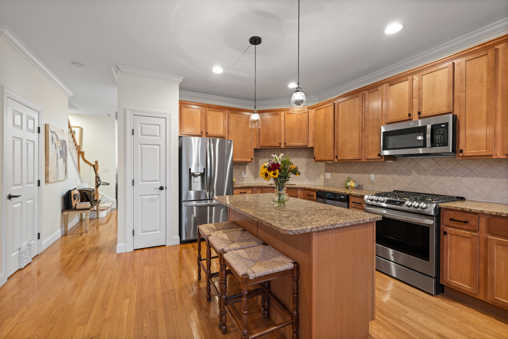 13 Mercy Street, Unit 13 Danbury, CT 06810 - Photo 6 of 40 a kitchen with stainless steel appliances granite countertop wooden cabinets a sink a stove a refrigerator and island with wooden floor
