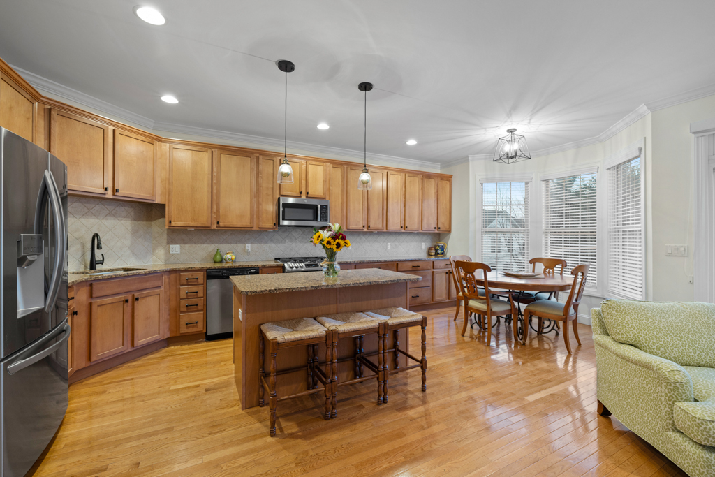 13 Mercy Street, Unit 13 Danbury, CT 06810 - Photo 7 of 40 a kitchen with stainless steel appliances granite countertop a stove top oven a sink dishwasher a dining table and chairs with wooden floor