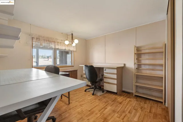a view of a workspace with furniture and a window