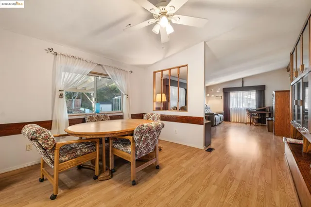 a dining room with furniture a chandelier and wooden floor