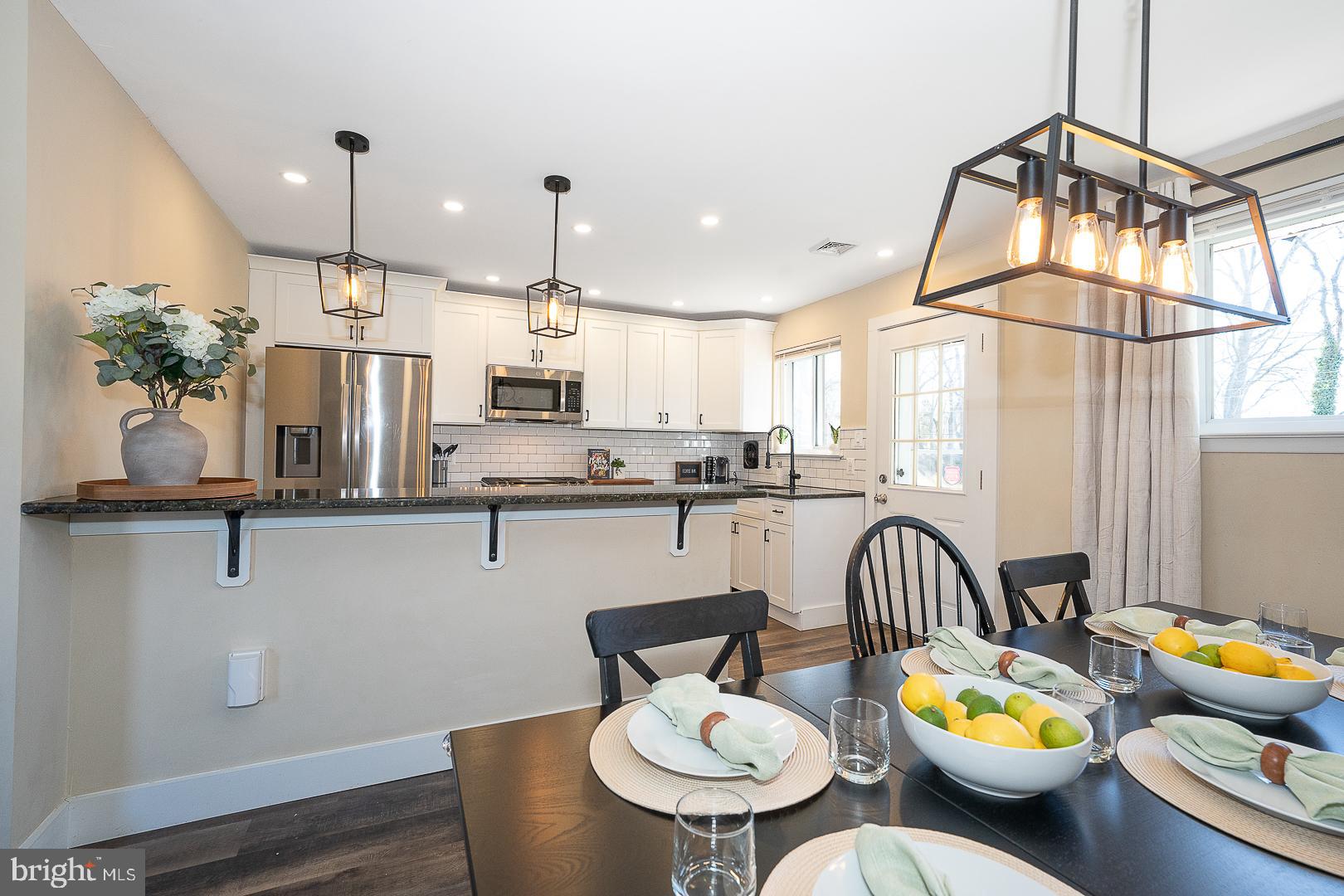334 Parham Road Springfield, PA 19064 - Photo 11 of 45 a kitchen with stainless steel appliances granite countertop a dining table chairs and white cabinets
