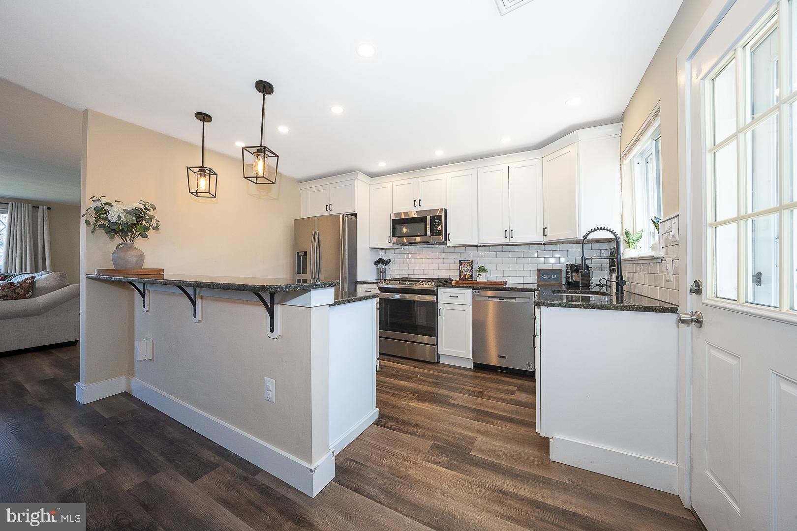 334 Parham Road Springfield, PA 19064 - Photo 7 of 45 a kitchen with kitchen island white cabinets and wooden floor