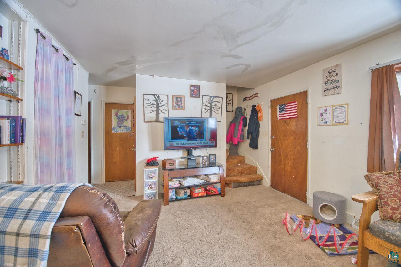 417 Arlington Road Hoyt Lakes, MN 55750 - Photo 8 of 32 Carpeted living room with stairway