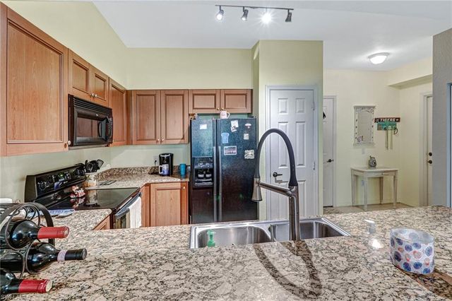 a kitchen with stainless steel appliances granite countertop a refrigerator stove and sink