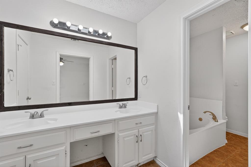 2403 Ridgevalley Drive McKinney, TX 75071 - Photo 17 of 21 a bathroom with a tub a double vanity sink and mirror