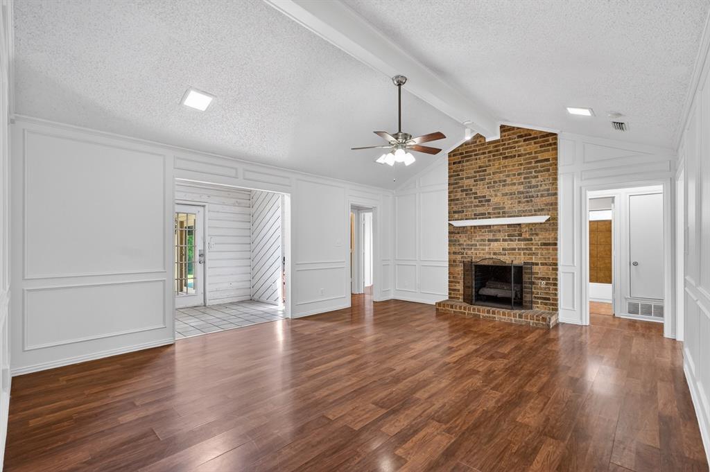 2403 Ridgevalley Drive McKinney, TX 75071 - Photo 5 of 21 an empty room with wooden floor fireplace and windows