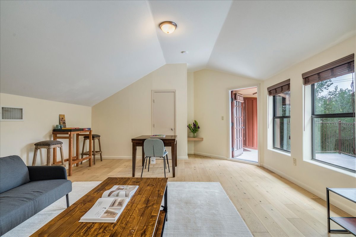 3012 South 4th Street, Unit B Austin, TX 78704 - Photo 26 of 40 Bright living area featuring wood-finish flooring, white vaulted ceilings, and multiple windows with dark blinds