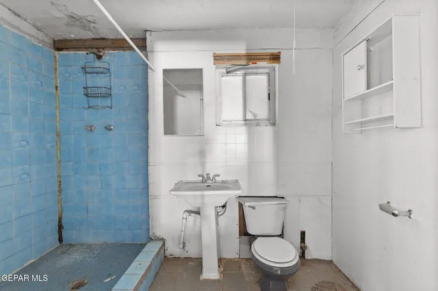 a bathroom with a granite countertop sink a toilet and shower