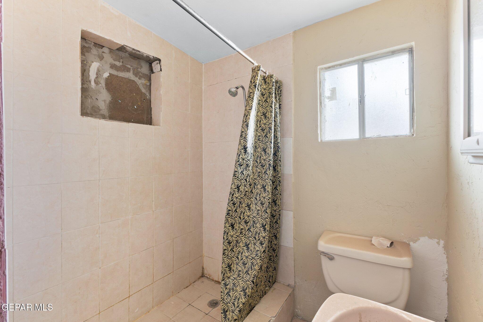 7080 2nd Avenue Canutillo, TX 79835 - Photo 35 of 38 a white toilet sitting next to a shower curtain
