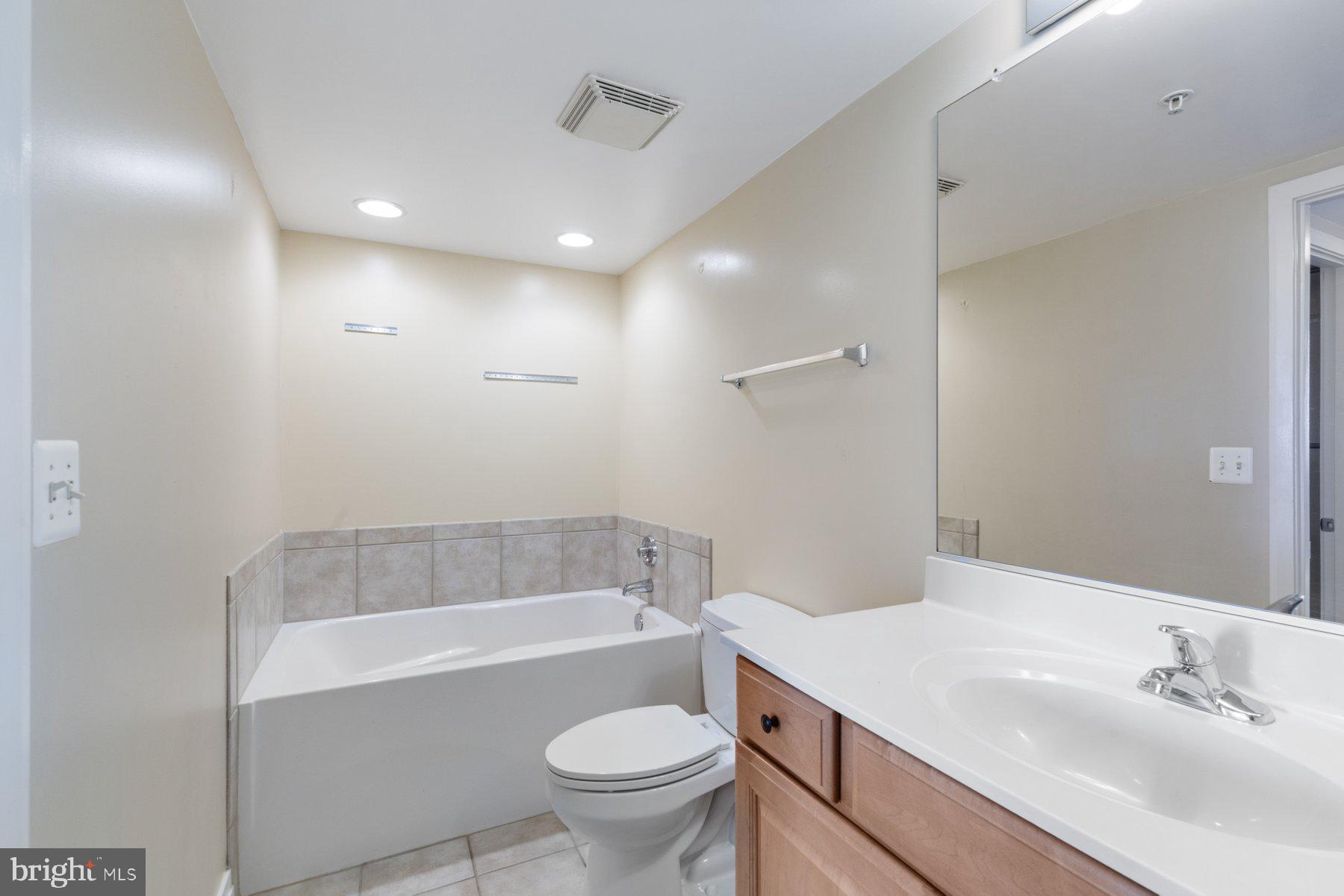 414 Water Street, Unit 2512 Baltimore, MD 21202 - Photo 19 of 40 a bathroom with a sink toilet bathtub and vanity