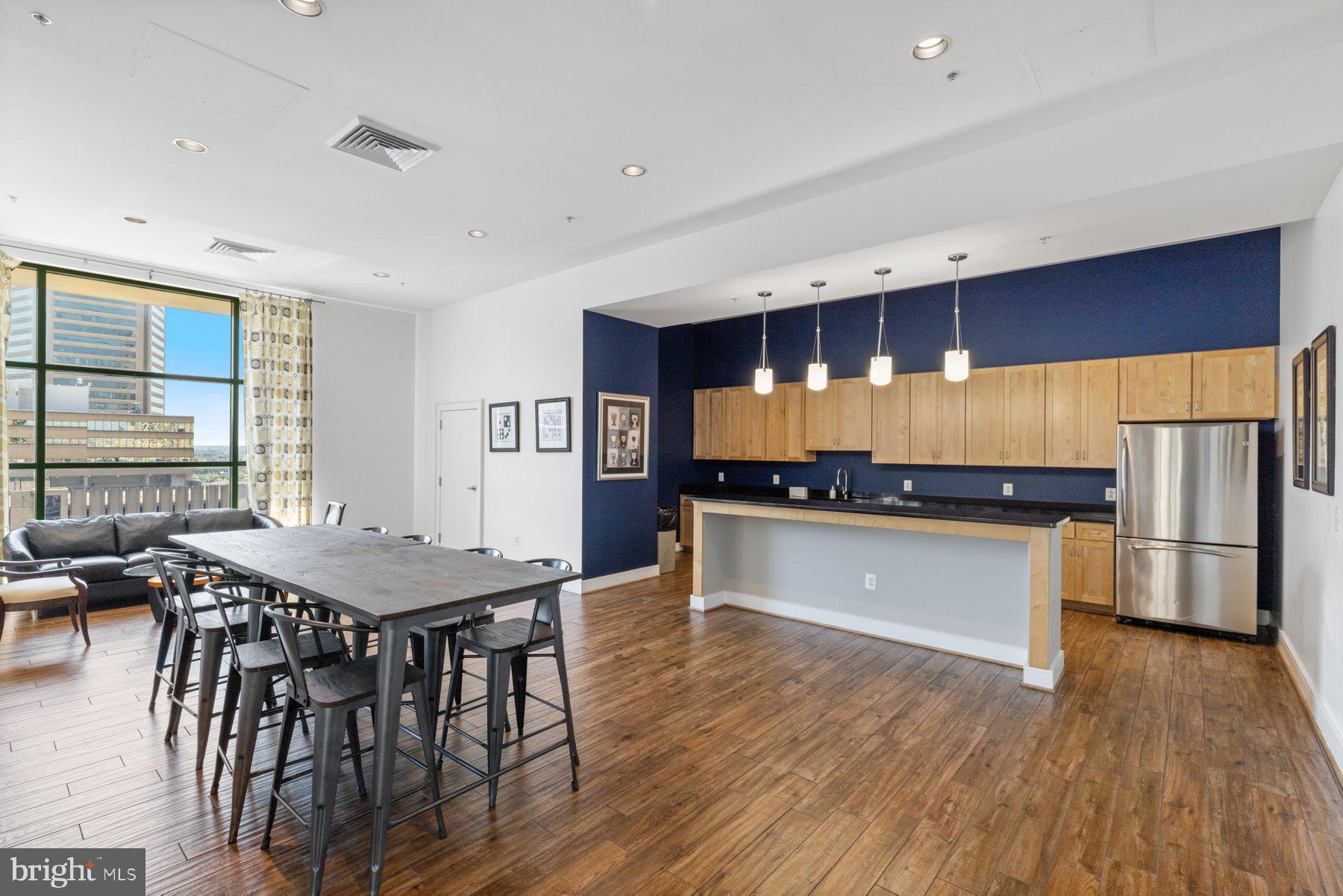 414 Water Street, Unit 2512 Baltimore, MD 21202 - Photo 33 of 40 a kitchen with stainless steel appliances wooden floors dining table and chair