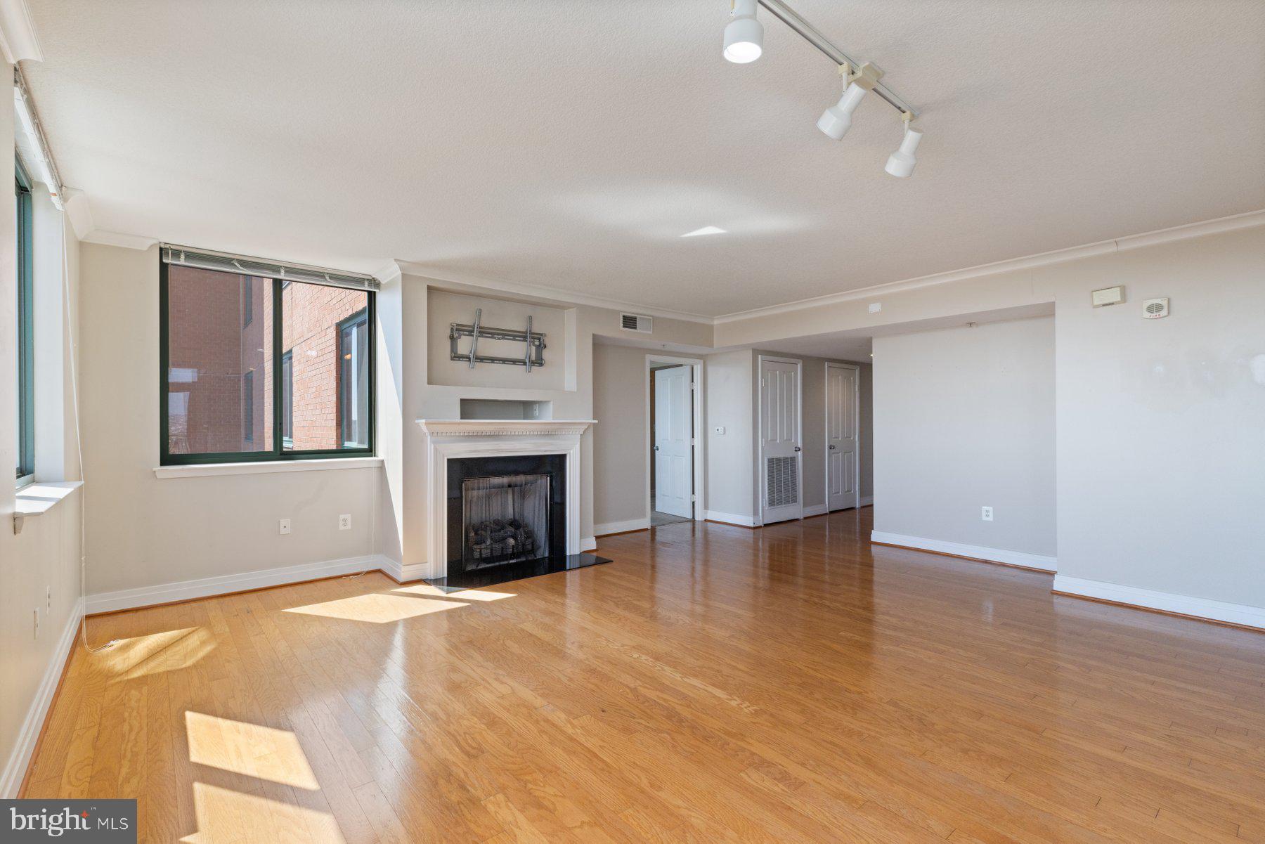 414 Water Street, Unit 2512 Baltimore, MD 21202 - Photo 6 of 40 an empty room with windows fireplace and cabinet