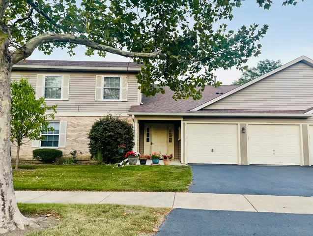 a front view of a house with a garden and plants