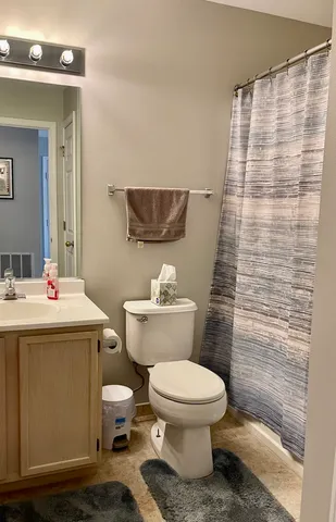 a bathroom with a sink a toilet and shower curtain