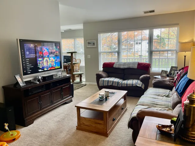 a living room with furniture a large window and a flat screen tv