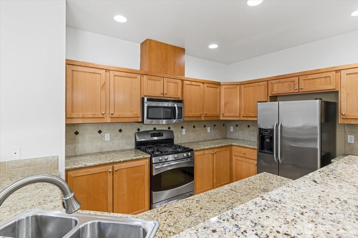 19102 20th Drive Southeast, Unit B206 Bothell, WA 98012 - Photo 16 of 39 a kitchen with stainless steel appliances granite countertop a refrigerator sink stove microwave and cabinets