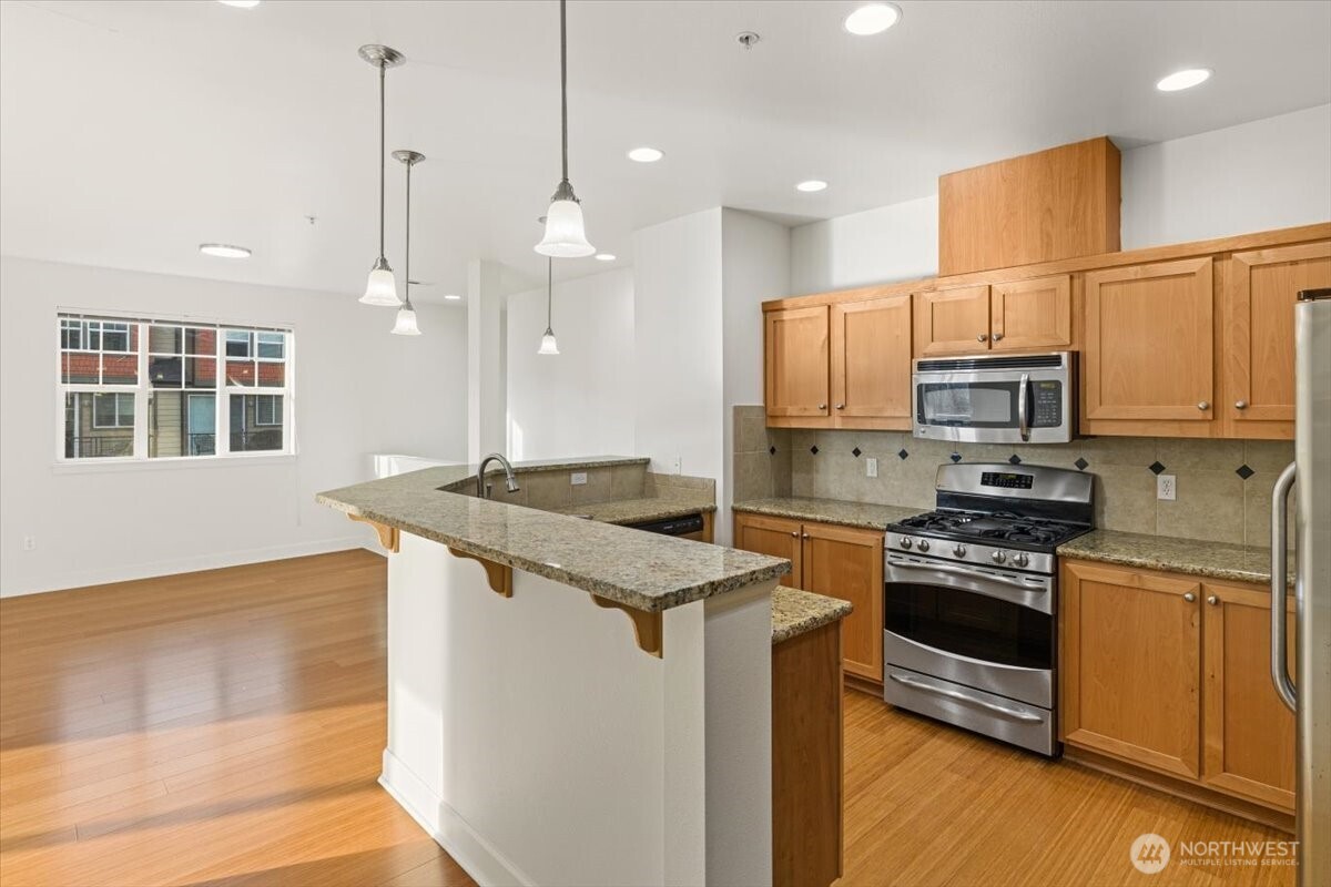 19102 20th Drive Southeast, Unit B206 Bothell, WA 98012 - Photo 17 of 39 a kitchen with stainless steel appliances granite countertop a stove a sink and a refrigerator
