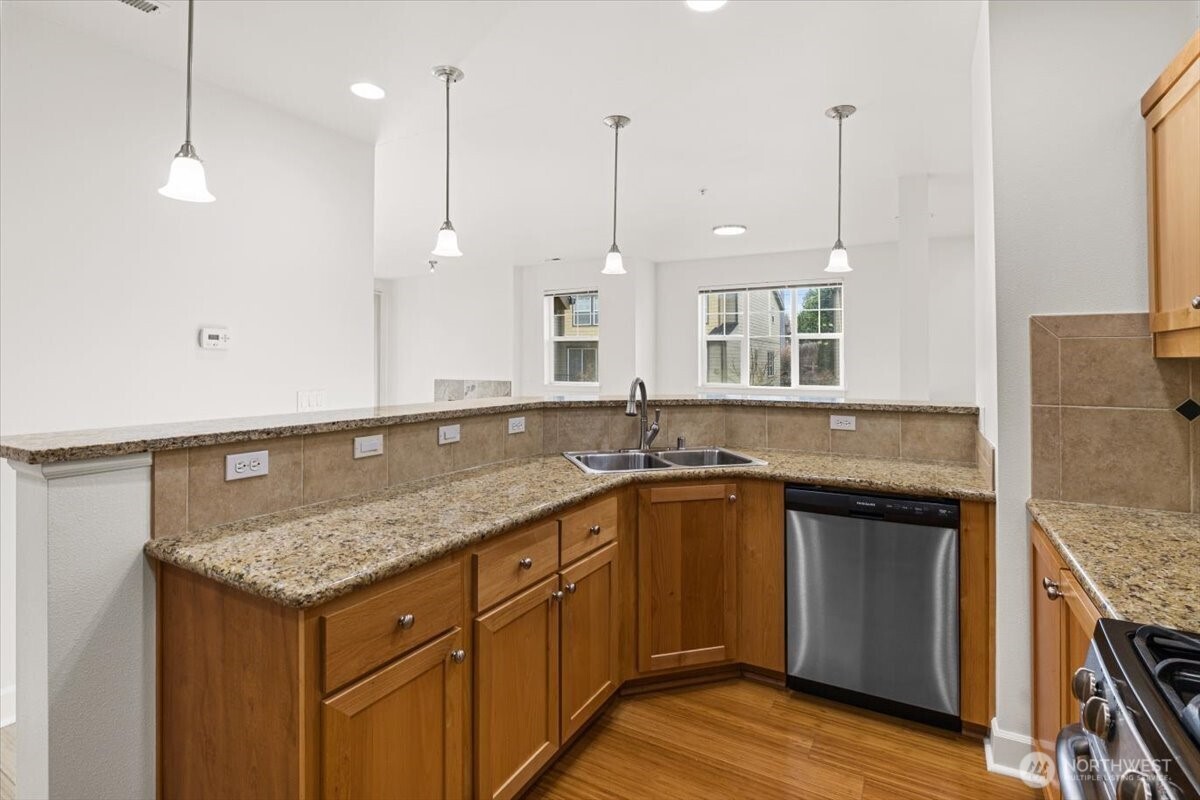 19102 20th Drive Southeast, Unit B206 Bothell, WA 98012 - Photo 21 of 39 a kitchen with a sink a stove and a wooden floor