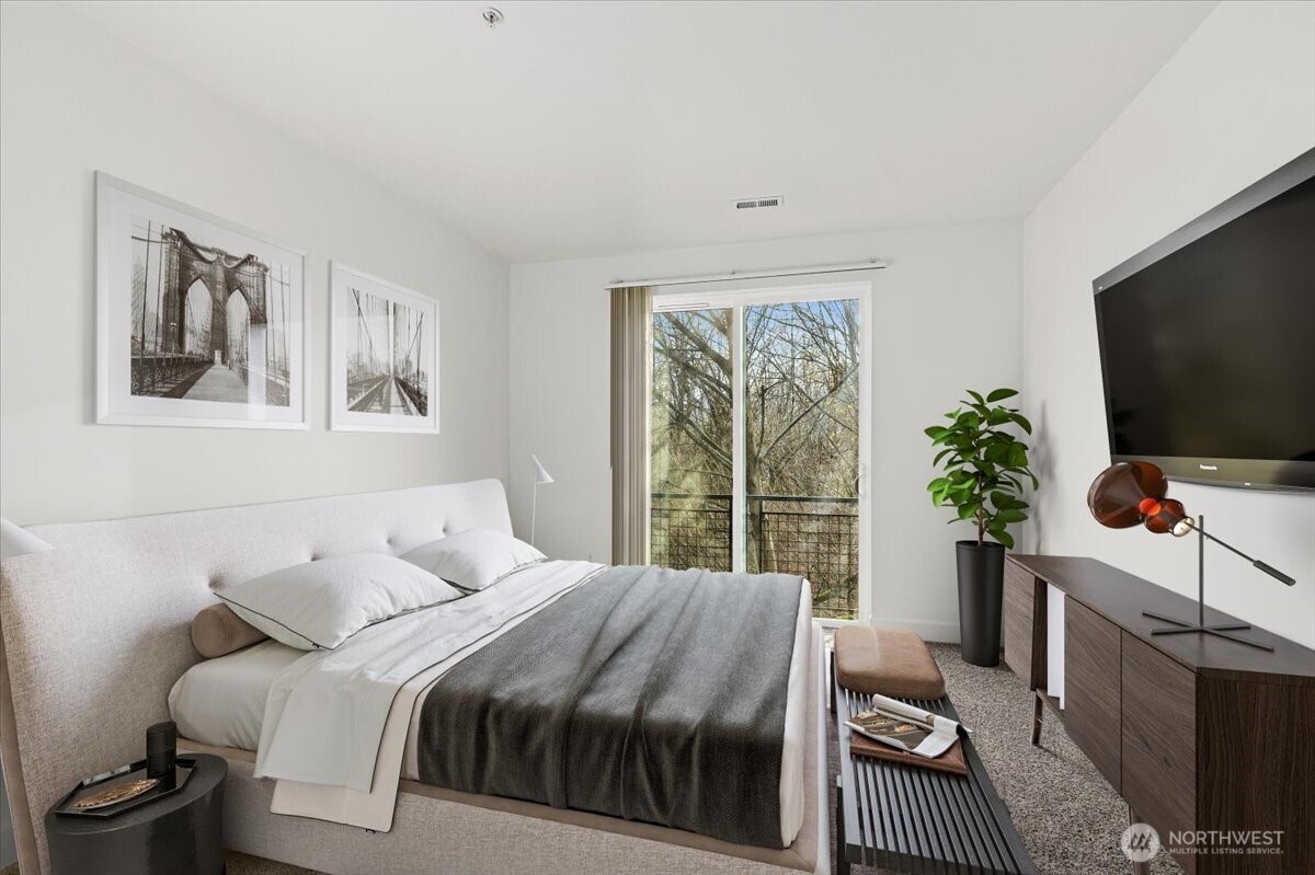 19102 20th Drive Southeast, Unit B206 Bothell, WA 98012 - Photo 24 of 39 a bedroom with a bed and a flat screen tv