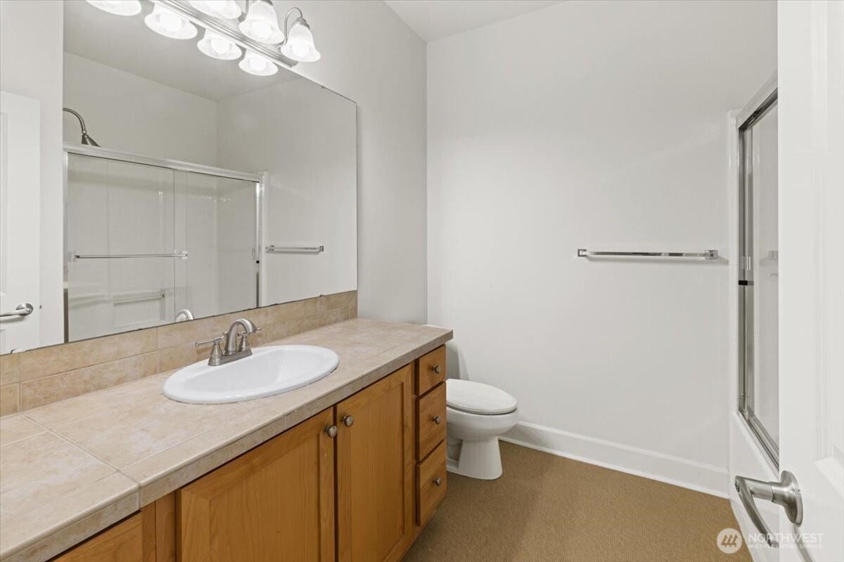 19102 20th Drive Southeast, Unit B206 Bothell, WA 98012 - Photo 34 of 39 a bathroom with a granite countertop sink a toilet and a mirror