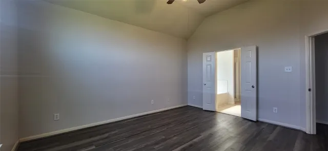 a view of an empty room with wooden floor and closet