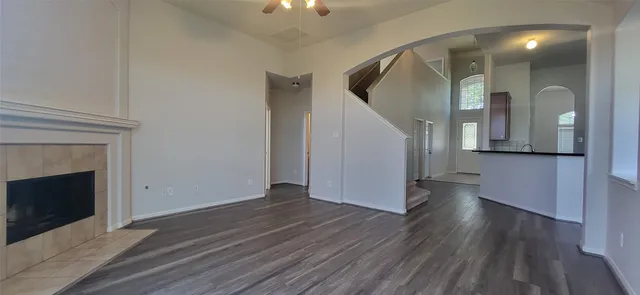 a view of a livingroom with wooden floor and a fireplace