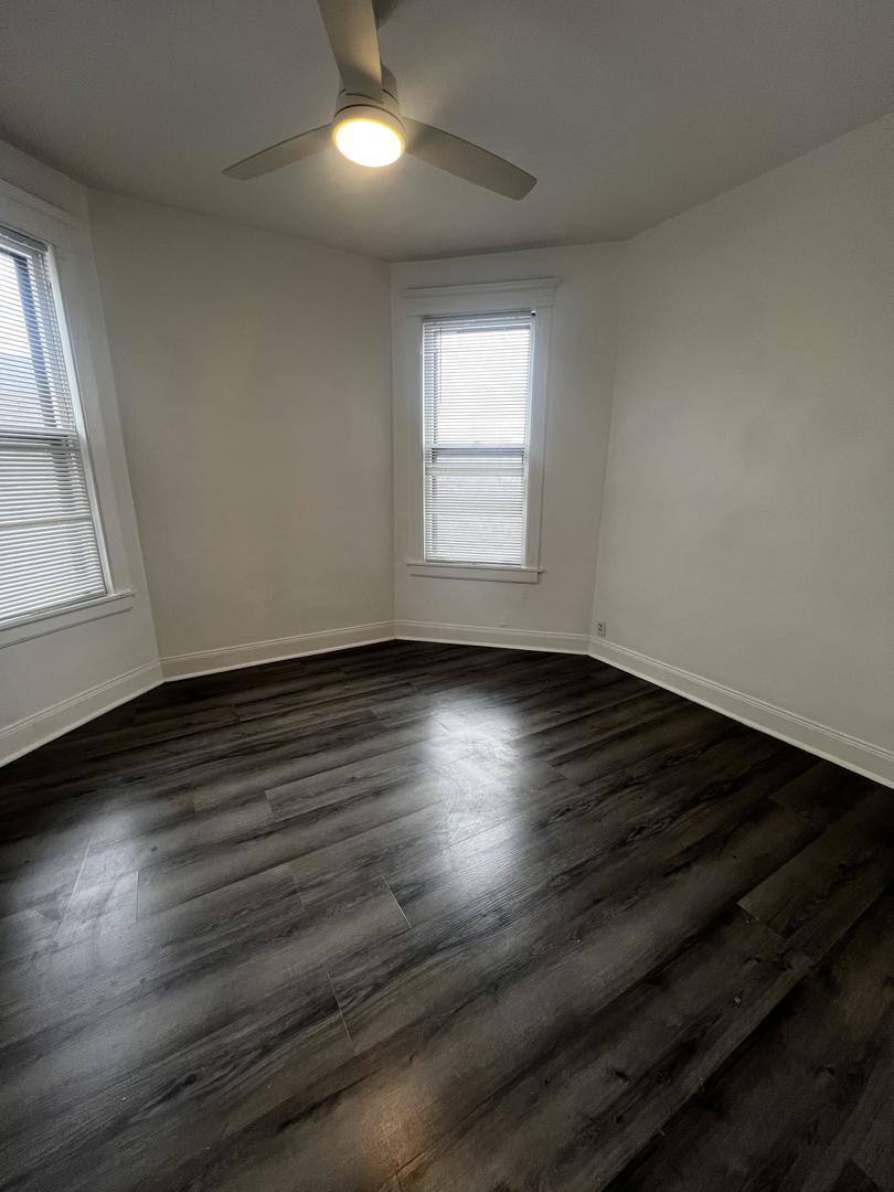 5461 West Haddon Avenue, Unit 2 Chicago, IL 60651 - Photo 15 of 21 an empty room with wooden floor and windows
