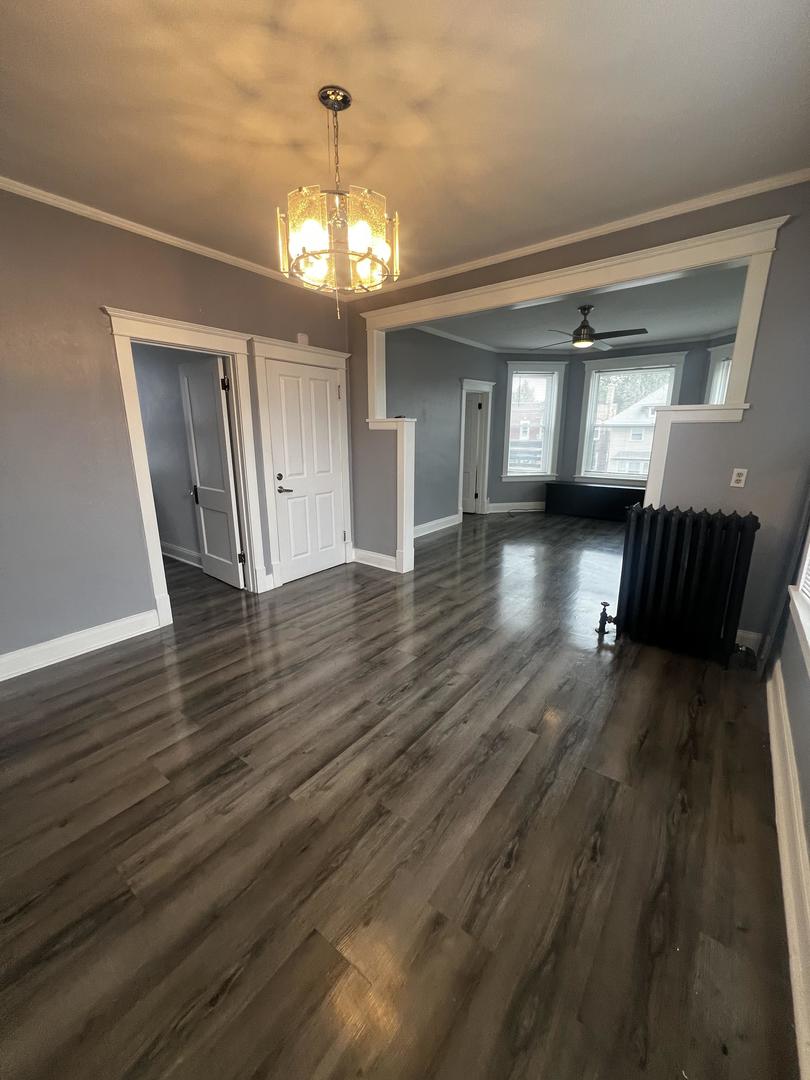 5461 West Haddon Avenue, Unit 2 Chicago, IL 60651 - Photo 3 of 21 a view of an empty room with wooden floor and a window