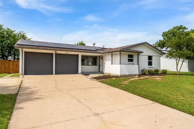 a front view of a house with a garden and yard