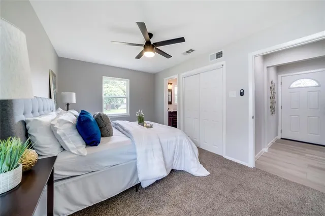 a bed room with a bed and a ceiling fan