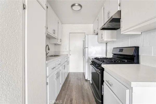 a kitchen with stainless steel appliances a sink stove and refrigerator