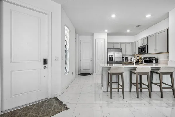 a kitchen with stainless steel appliances granite countertop a refrigerator and a sink
