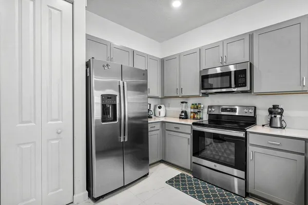 a kitchen with stainless steel appliances granite countertop a stove a refrigerator and a microwave