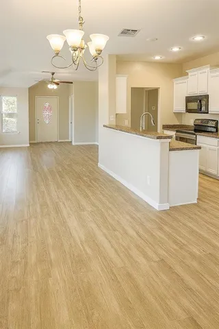 a view of a kitchen with granite countertop cabinets and wooden floor